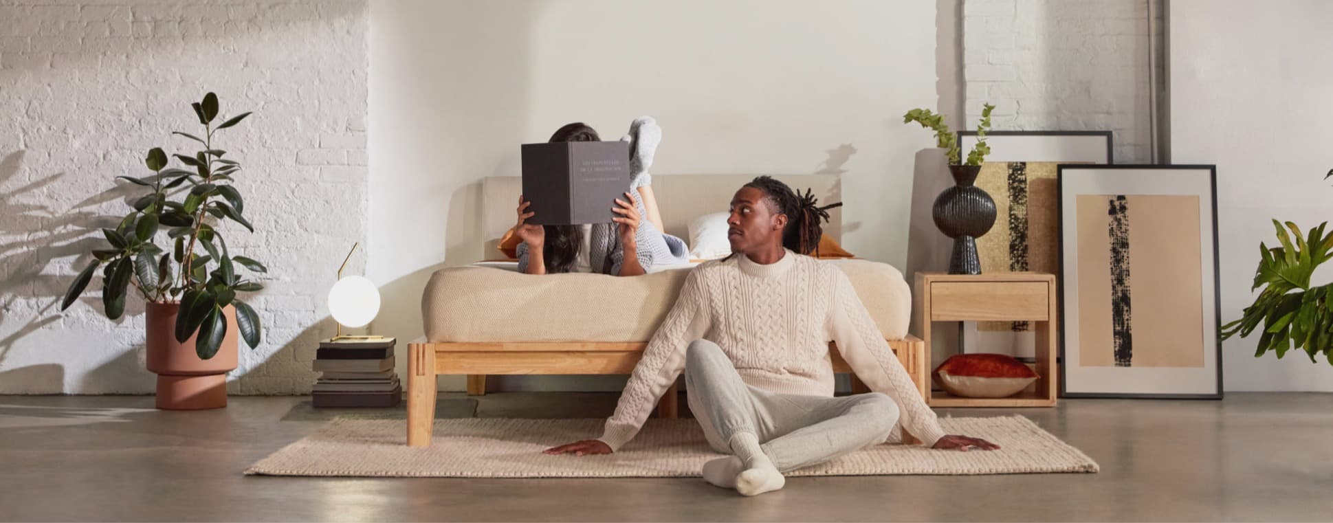 The Bed in natural with two models in a styled room